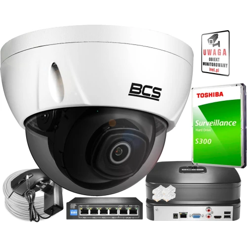 The image features a BCS dome security camera with a sleek white design, accompanied by a Toshiba surveillance hard drive and various installation accessories. The setup includes a network switch, cables, and a warning sign, ideal for comprehensive security solutions.