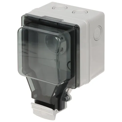 The image shows a weatherproof electrical outlet with a transparent, hinged cover designed for outdoor use. The outlet is encased in a durable, gray plastic housing with multiple cable entry points.