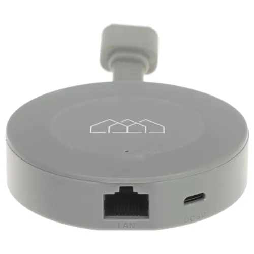 A round, gray smart home hub features a LAN port and a micro USB power input on its side. The device has a minimalist design with a subtle logo on the top surface.