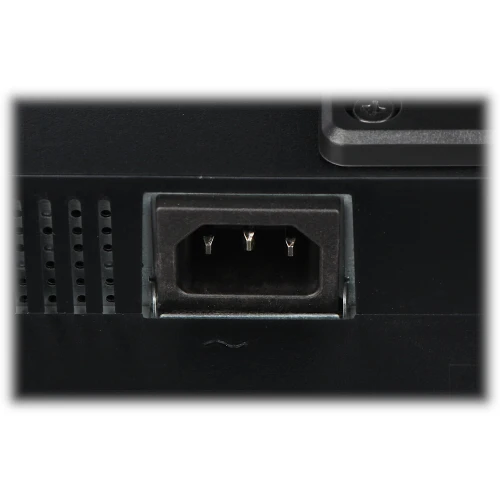 Close-up of a black power socket on an electronic device, featuring three metal prongs inside a rectangular housing. The surrounding area shows ventilation slots and part of the device's casing.