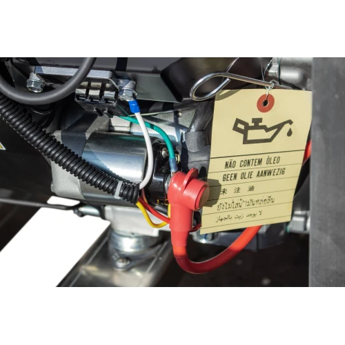 The image shows a close-up of a generator with various wires and a red cap, highlighting its intricate components. A multilingual tag is attached, indicating the absence of oil in the machine.