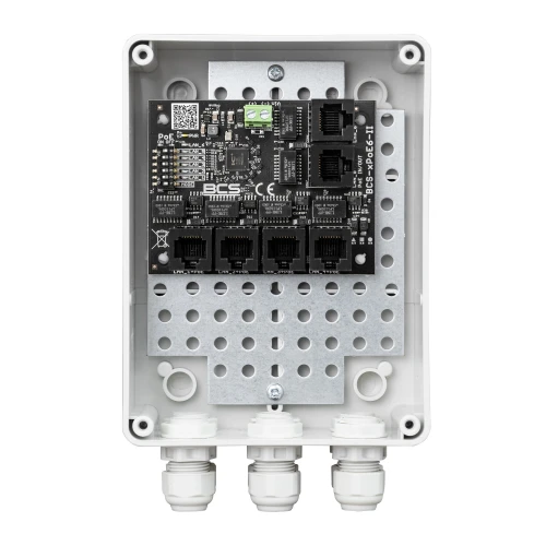 The image shows a BCS PoE switch enclosed in a white, weatherproof casing with multiple Ethernet ports visible on the circuit board. The casing features three cable glands at the bottom for secure cable management.