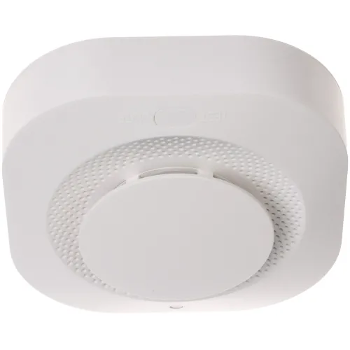 A sleek, white wireless smoke detector with a central circular sensor and a textured surface for enhanced grip. The device features a test button for easy functionality checks.
