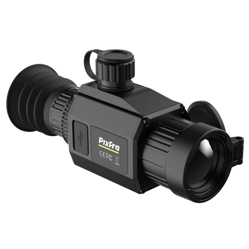 A black thermal imaging monocular with a textured grip and adjustable focus ring, featuring a flip-up lens cover. The device has a USB port and visible certification markings on the side.