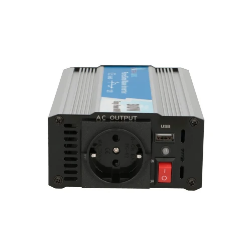 The image shows a power inverter with a European AC outlet, USB port, and an on/off switch on the front panel. The device features a metallic casing with a blue label on top, indicating its specifications.