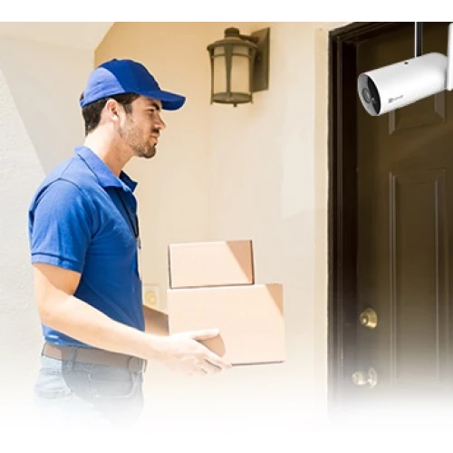 A smart security camera is mounted above a doorway, capturing clear footage of a delivery person holding packages. The camera is designed for outdoor use, featuring a sleek white casing and advanced connectivity options.