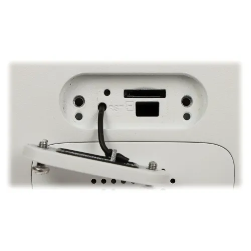 The image shows a close-up of a white electronic device featuring a memory card slot and a reset button. The cover is partially open, revealing the internal components and wiring.