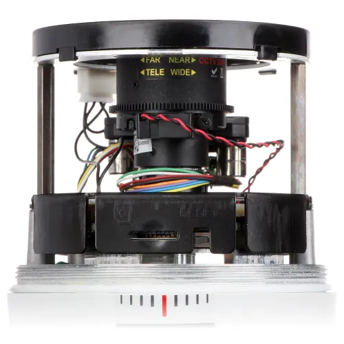 The image shows a close-up of a camera module featuring a memory card slot and a reset button, surrounded by various colored wires. The lens is adjustable with markings for focus and zoom settings, indicating options for far, near, tele, and wide adjustments.