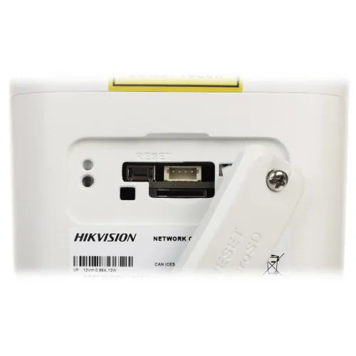 The image shows a close-up of a Hikvision network camera featuring a memory card slot and a reset button. The camera's casing is white with clearly labeled components for easy access and operation.