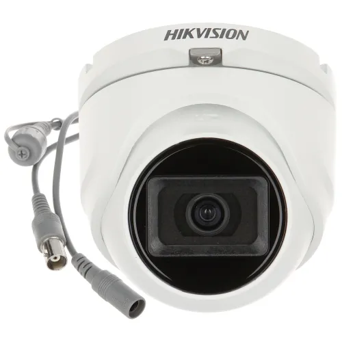 A white Hikvision dome security camera with a sleek design features a prominent lens and multiple connection cables. The camera is designed for high-definition surveillance, suitable for both indoor and outdoor use.