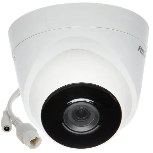 A white Hikvision dome-shaped IP camera with a black lens and attached cables is shown. The camera is designed for security surveillance, featuring a sleek and modern design.