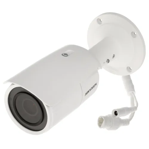 A white Hikvision IP camera with a sleek, cylindrical design is mounted on a sturdy base. The camera features adjustable lenses and multiple connection cables for versatile installation.
