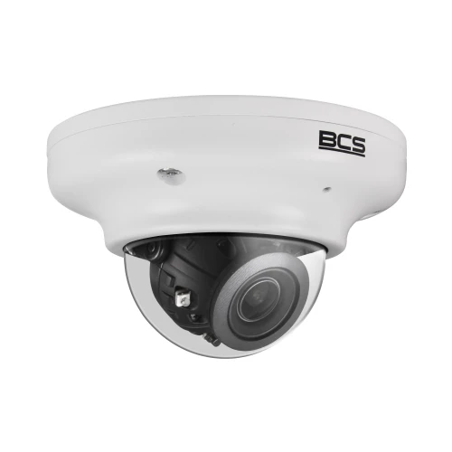 A white dome-shaped IP camera with a clear protective cover and visible lens, designed for security surveillance. The camera features the BCS logo on its casing, indicating its brand.