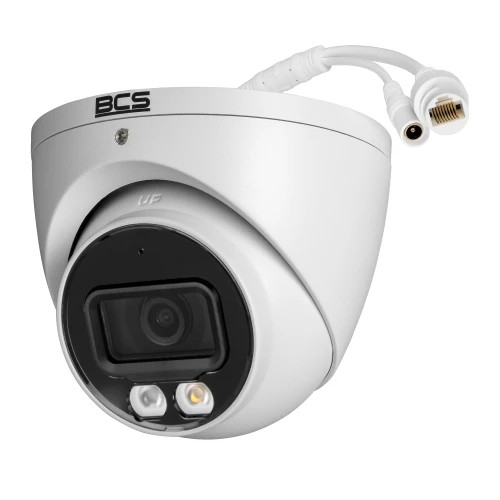 A white dome-shaped IP camera with a sleek design features a prominent lens and two LED lights for enhanced visibility. The camera includes a BCS logo on top and has connectors for power and network connectivity.