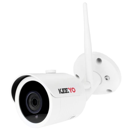 A white, cylindrical IP network bullet camera with a prominent lens and an antenna for wireless connectivity is mounted on a wall bracket. The camera features the brand logo on its side and is designed for outdoor surveillance.