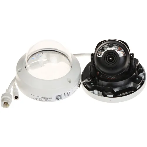 The image shows a disassembled dome security camera with its main components, including the lens and infrared LEDs, exposed. The camera is placed next to its protective dome cover and features connection cables for installation.