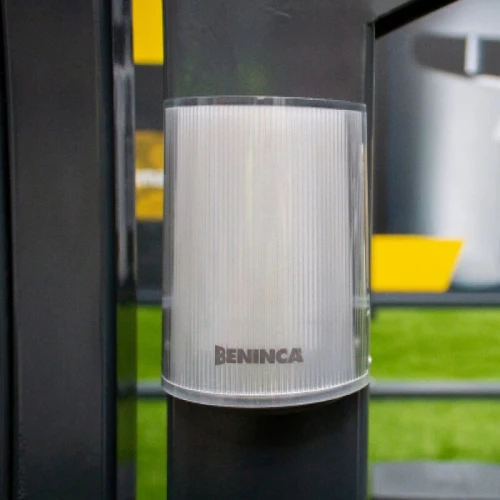 A sleek, cylindrical LED lamp with a ribbed translucent cover, designed for outdoor use. The lamp features the Beninca logo on its front, mounted on a dark surface.