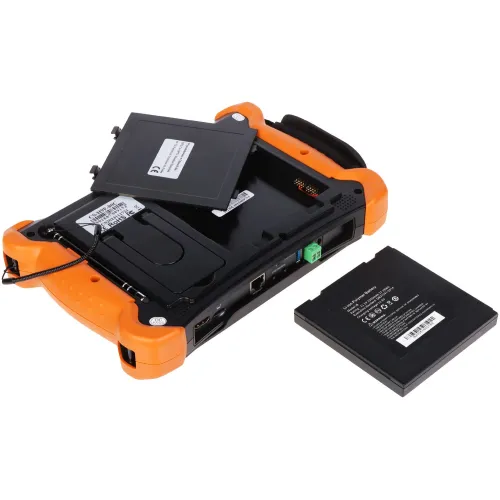 The image shows a portable electronic device with an open battery compartment, featuring an orange protective casing and various connectivity ports. A separate rechargeable battery is placed next to the device, ready for installation.