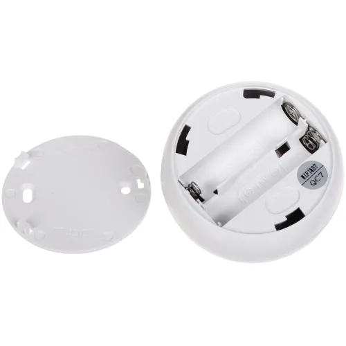 The image shows a round, white battery compartment designed to hold two AAA batteries, with the cover removed to reveal the battery slots. The cover features a simple locking mechanism to secure the batteries in place.