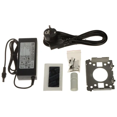 The image shows a power adapter set, including a power brick with a European plug, mounting hardware, and a metal bracket. Additional components include a small packet of screws, a plastic tube, and a piece of adhesive material.