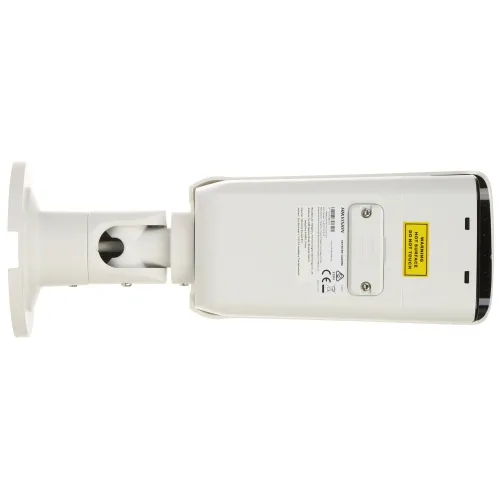 The image shows a white security camera with a sturdy mounting bracket, designed for outdoor surveillance. The camera features a warning label and various certification markings on its casing.