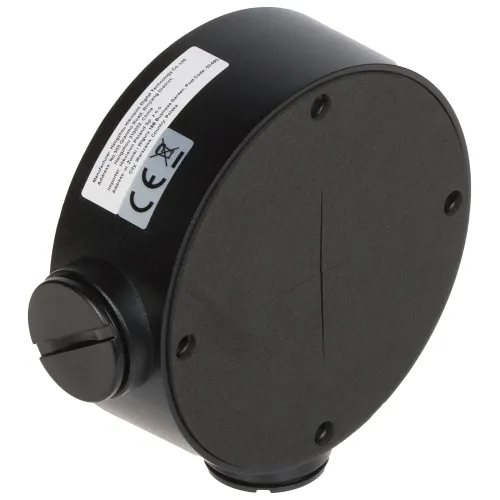 A round, black camera mounting bracket with a smooth surface and visible screw holes for secure attachment. The bracket features a side cable entry point and a label with safety and compliance information.