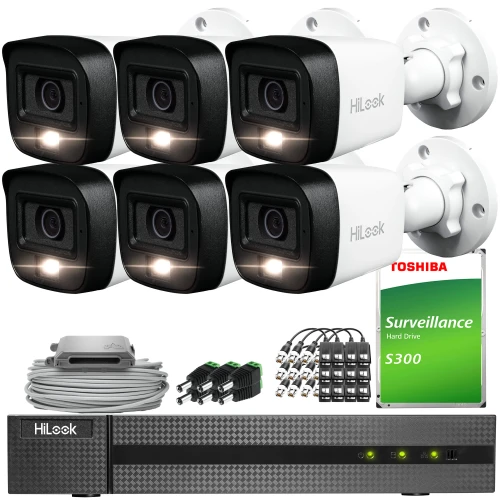 The image shows a comprehensive surveillance system package, including six HiLook security cameras, a Toshiba surveillance hard drive, and a HiLook DVR. Additional components include cables, connectors, and a power supply unit for complete installation.