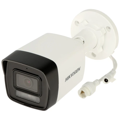 A white Hikvision security camera with a black front and lens is shown, featuring a sturdy mounting bracket and connection cables. The camera is designed for outdoor surveillance, providing high-quality video monitoring.
