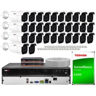 The image shows a comprehensive IP surveillance system kit, including multiple security cameras, a network video recorder, two network switches, a roll of cable, and a Toshiba surveillance hard drive. This setup is designed for extensive monitoring and recording capabilities in various environments.