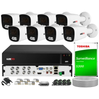 The image shows a comprehensive surveillance system featuring eight white security cameras and a central recording unit. Included are various cables, connectors, and a Toshiba surveillance hard drive for efficient video storage.