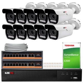 The image shows a comprehensive surveillance system featuring eight white security cameras, a network video recorder, and a Toshiba surveillance hard drive. The setup includes network switches and cables, designed for extensive monitoring and security coverage.