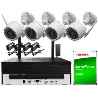 The image shows a Wi-Fi surveillance system featuring four white security cameras with mounting brackets, accompanied by a black recording unit. Included in the setup is a Toshiba Surveillance S300 hard drive, designed for reliable video storage.