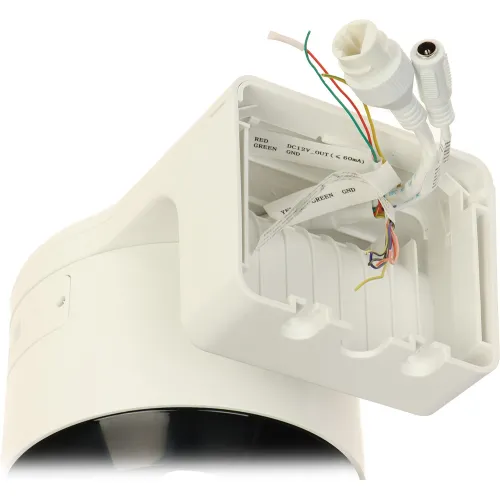 The image shows a white security camera with exposed wiring and connectors, including a DC power plug and an Ethernet cable. The camera's mounting bracket is open, revealing labeled internal connections for easy installation.